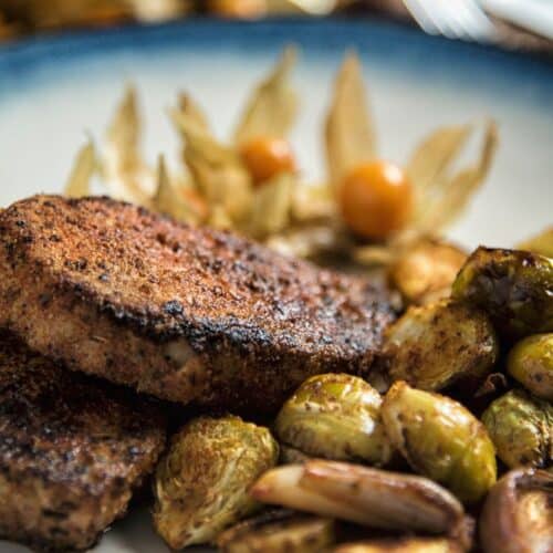 Paprika Pork Chops with Brussels Sprouts on a white plate.