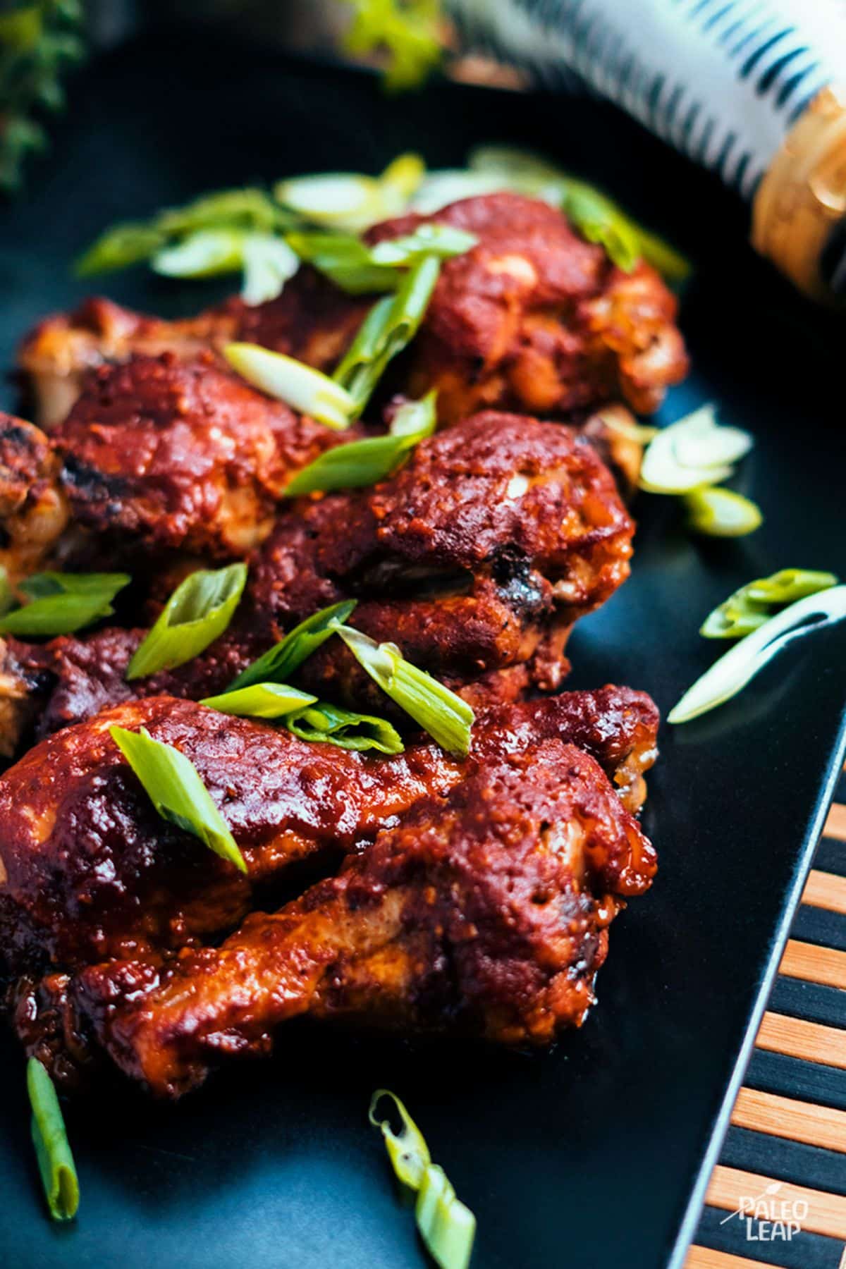 Slow Cooker BBQ Chicken Drumsticks on a black tray.