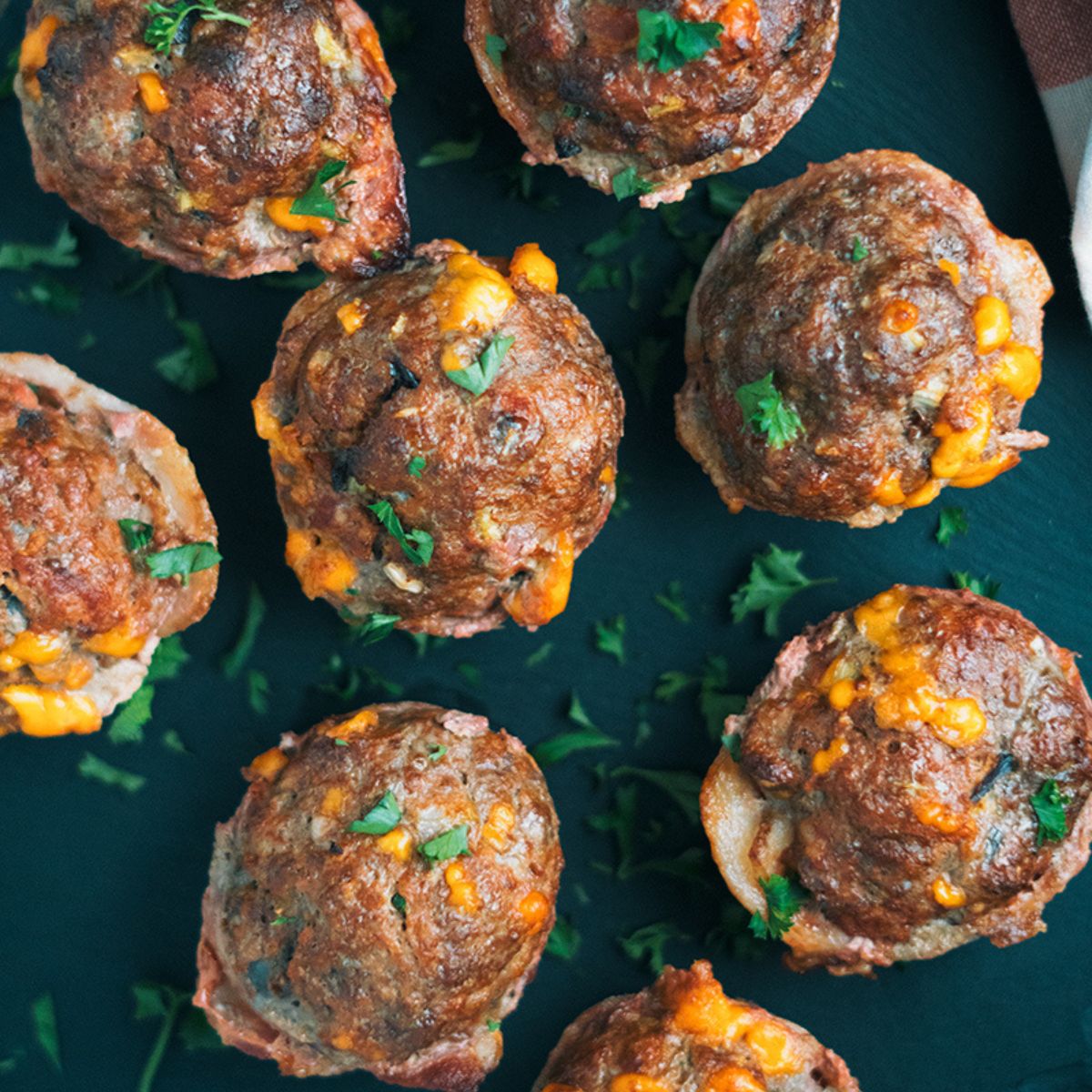 Keto Mini Cheeseburger Meatloaves on a black board.