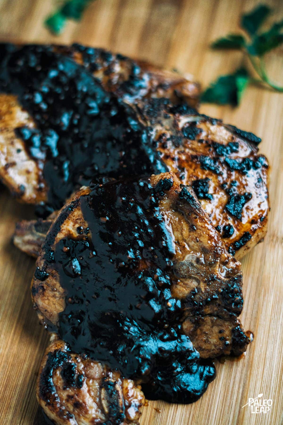 Pork Chops With Blackberry BBQ Sauce on a wooden cutting board.