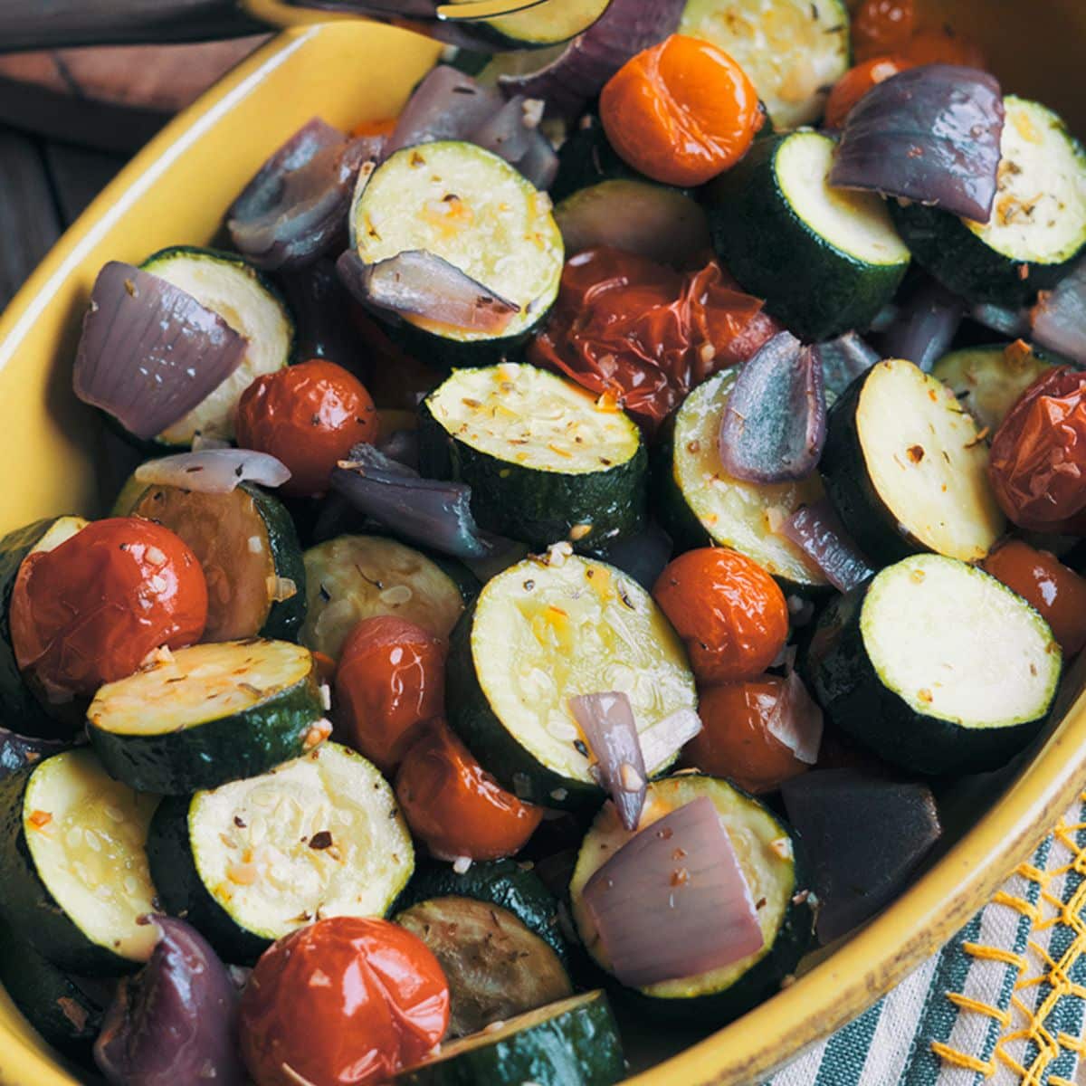 Roasted Italian Zucchini and Tomatoes in a yellow bowl.