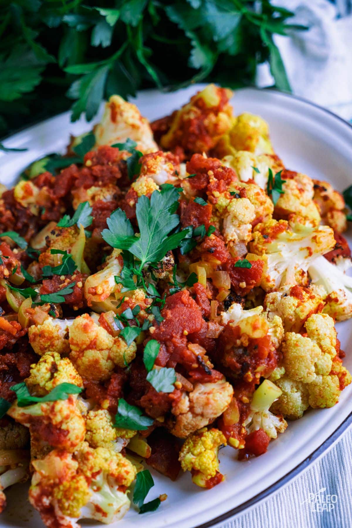 Curry Cauliflower and Tomatoes on a white tray.