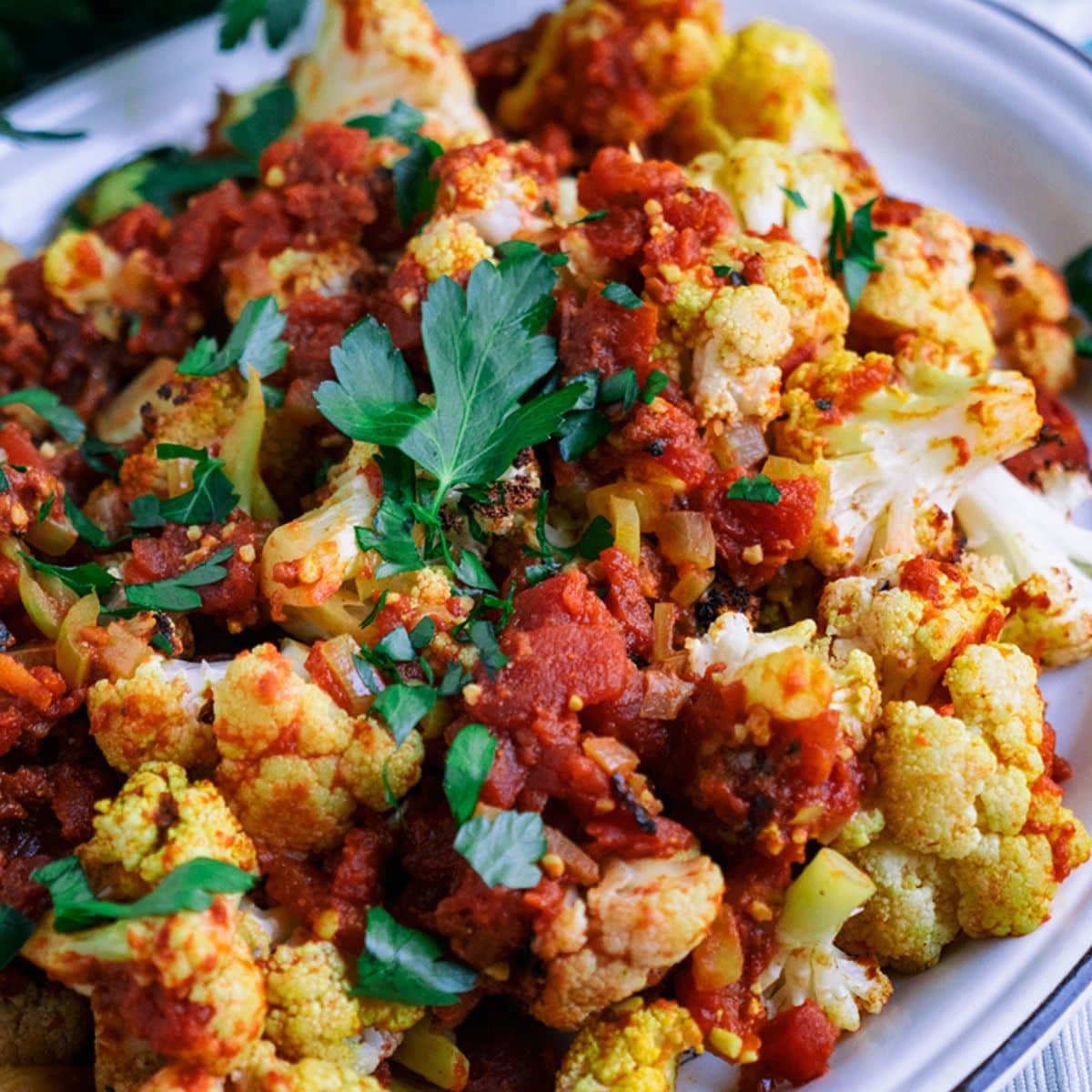 Curry Cauliflower and Tomatoes on a white tray.