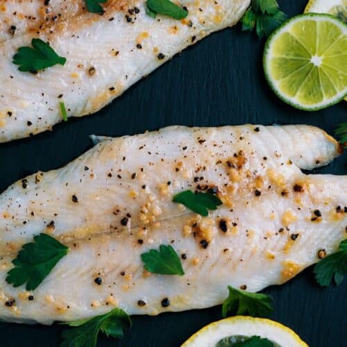 Lemon And Garlic Tilapia on a black board.