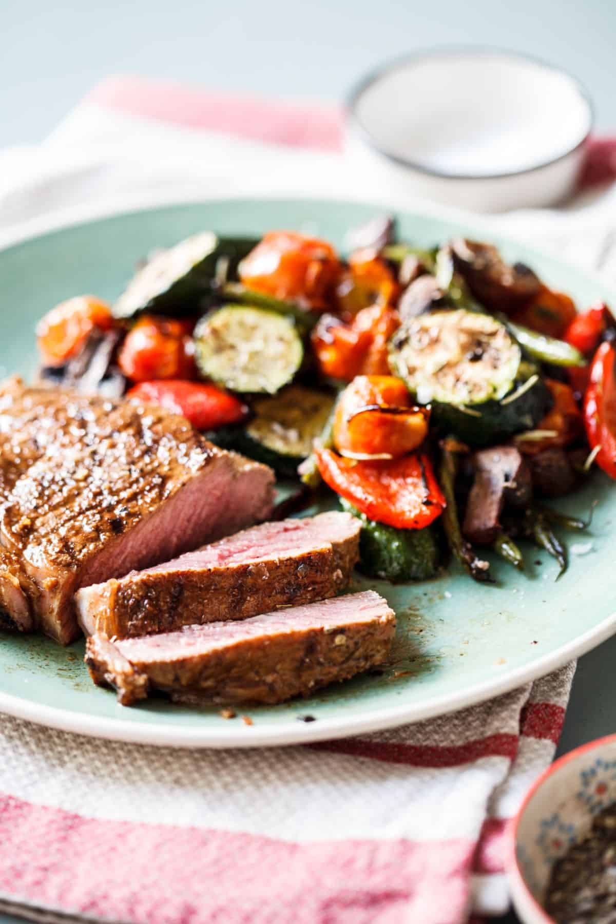 Garlic-Lime Steaks With Roasted Vegetables on a blue plate.
