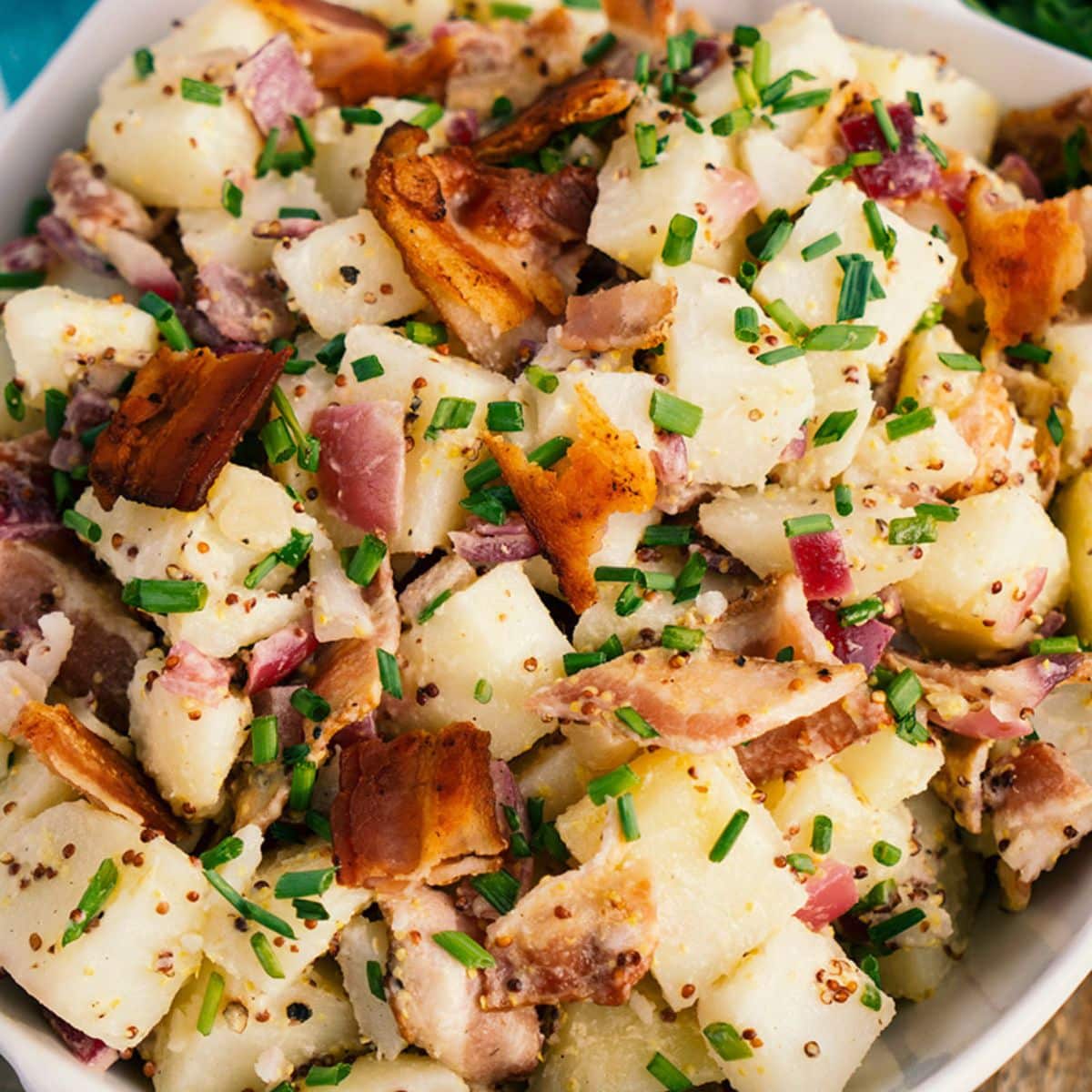 Grainy-Mustard And Bacon Potato Salad in a white bowl.
