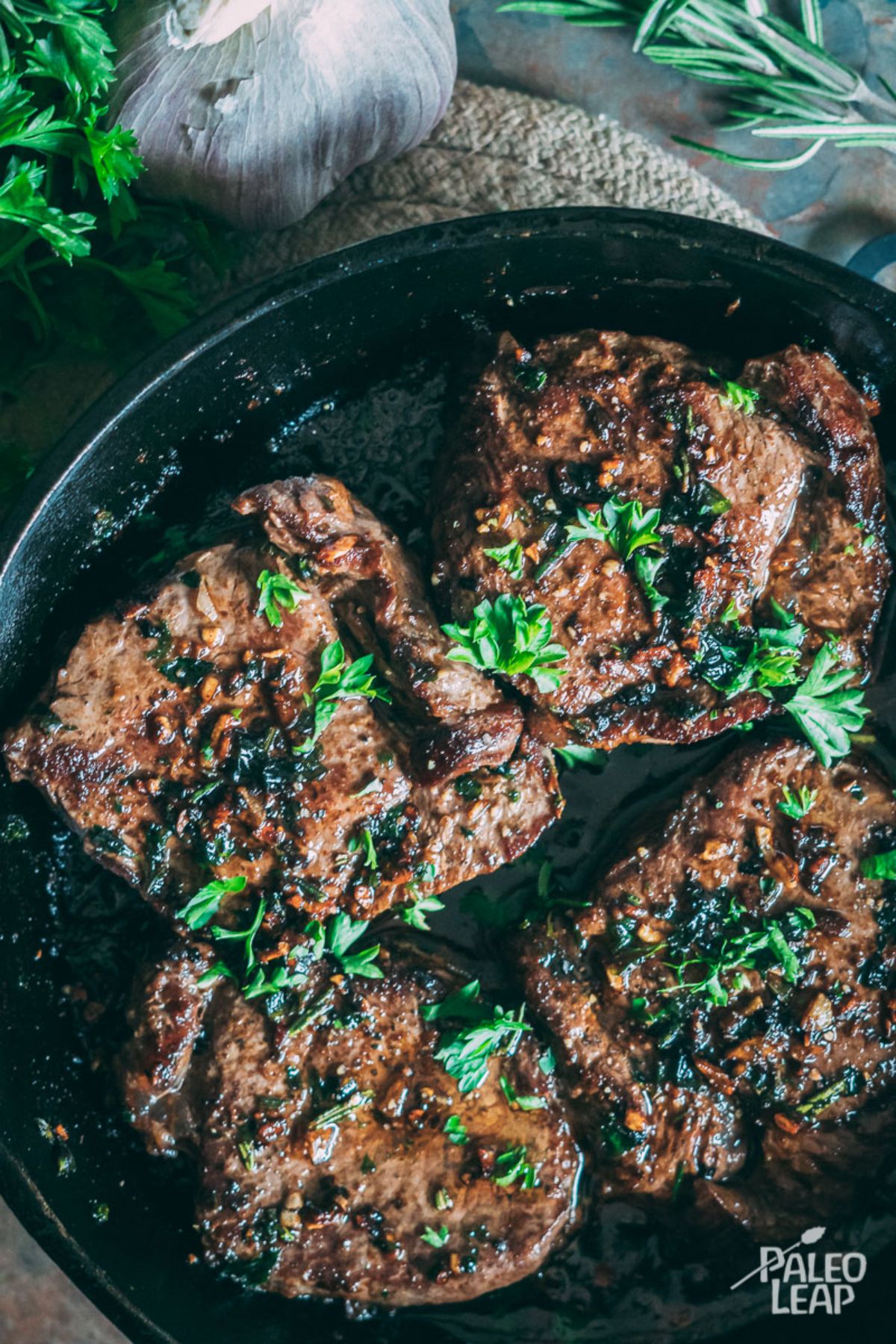 Garlic And Herb Steak in a black pan.