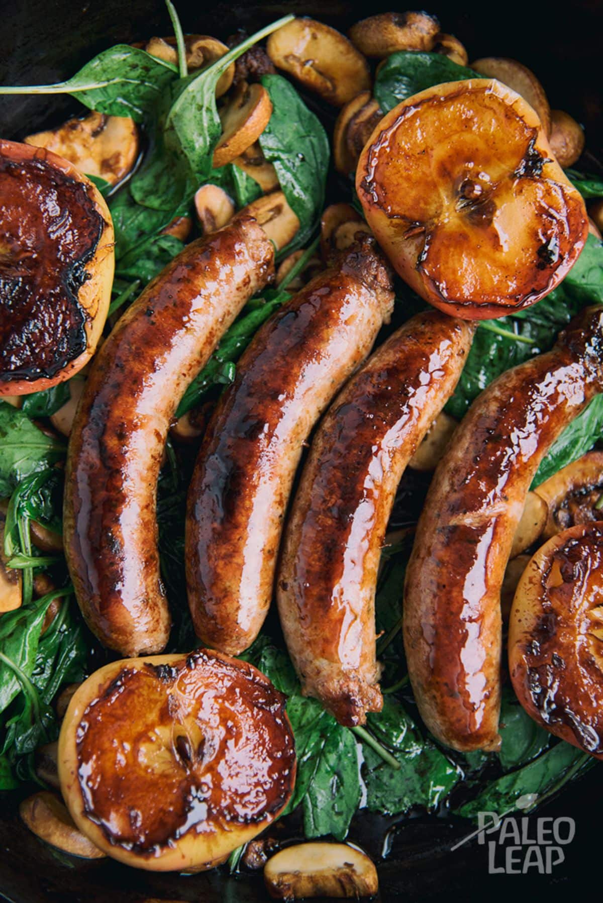 Skillet Sausages with Pan-Seared Apples in a black pan.