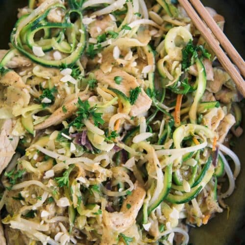 Almond Butter Chicken With Zucchini Noodles in a black pan with chopsticks.