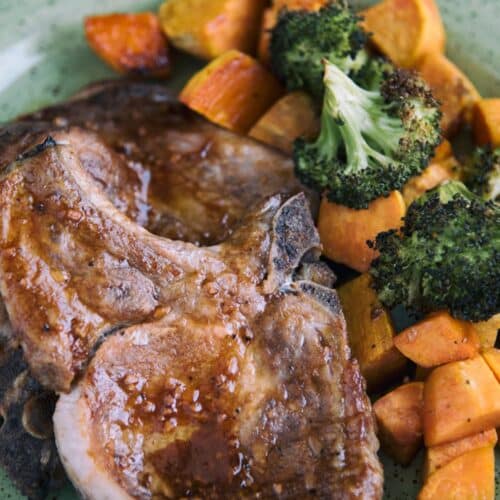 Oven Baked Pork Chops with Roasted Sweet Potatoes on a green plate.