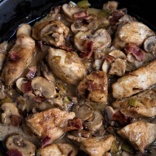 Creamy Chicken With Leek And Bacon in a black pan.