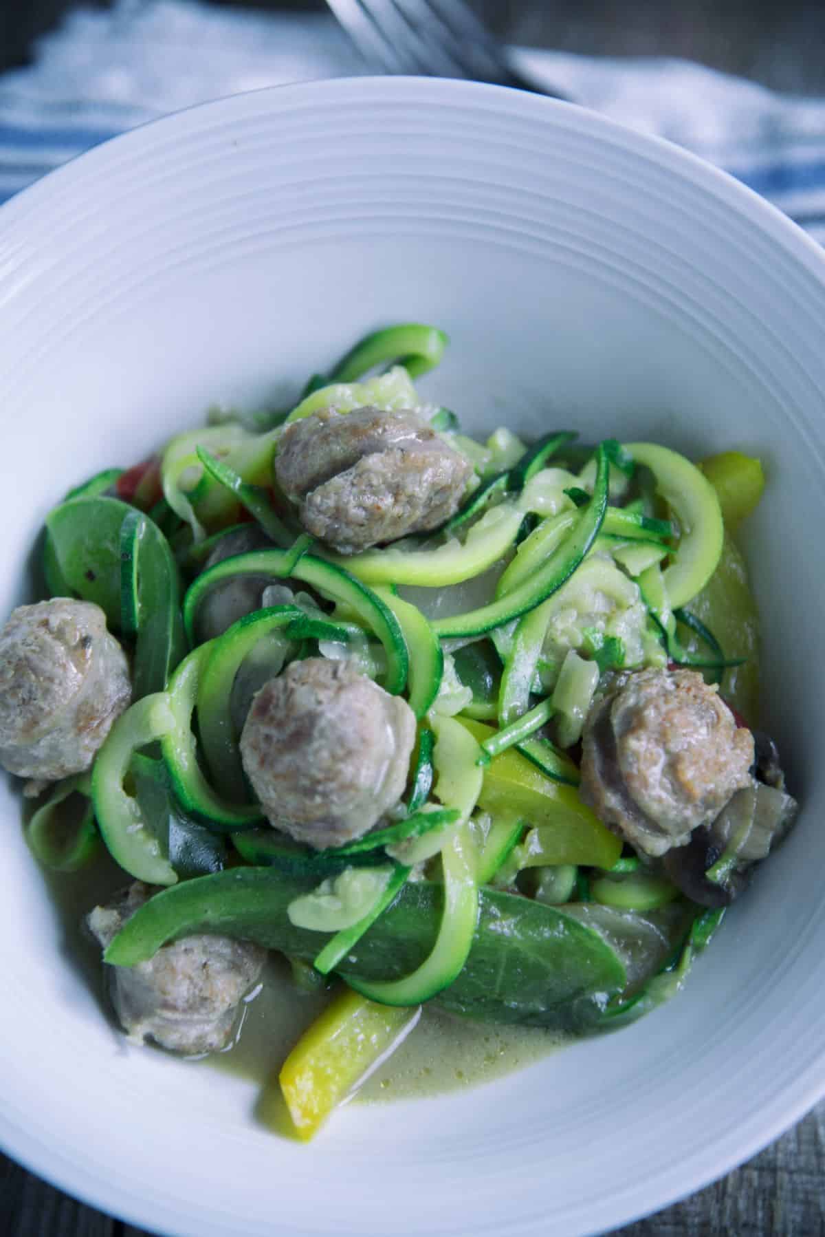 Zucchini Noodles With Sausage in a white bowl.