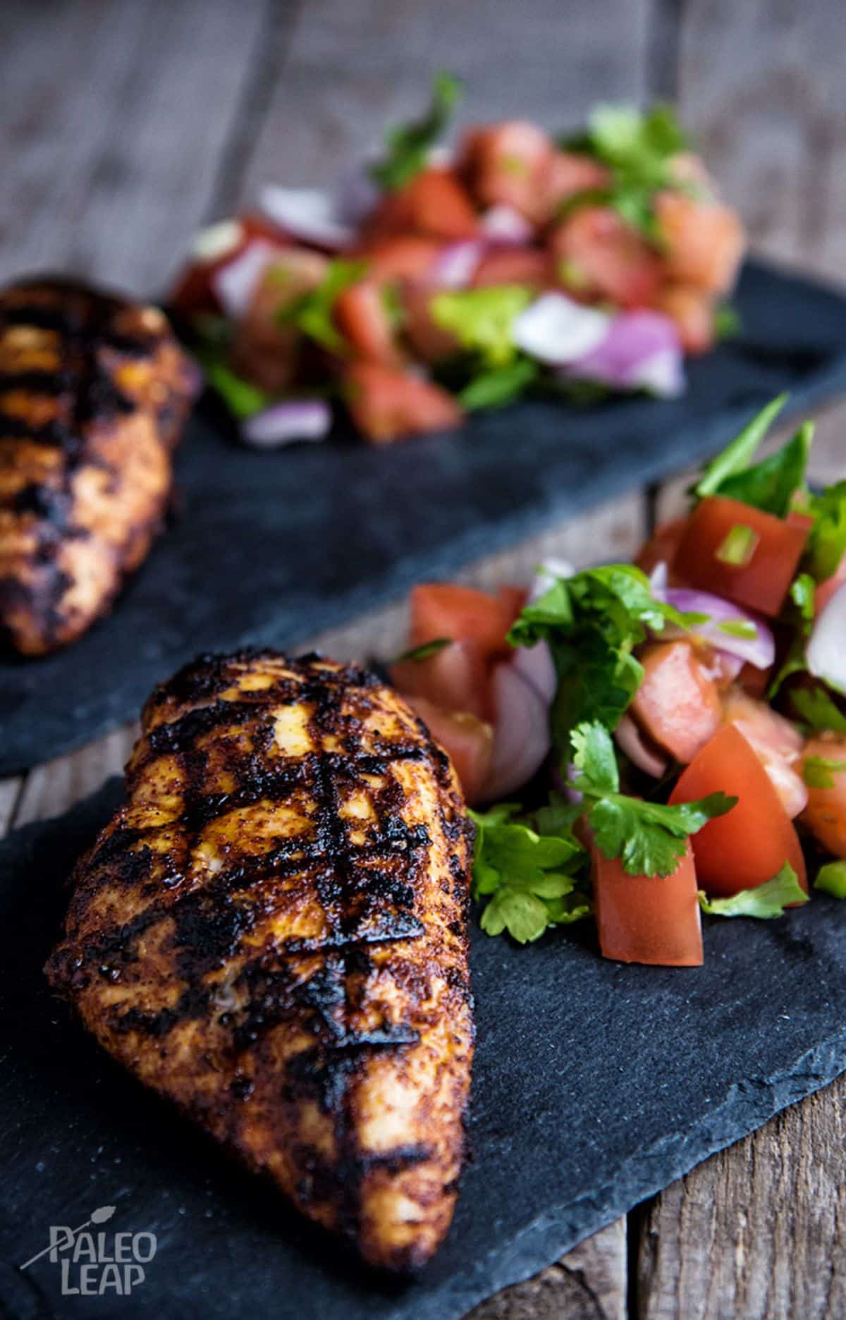 Grilled Mexican-Style Chicken With Chunky Pico de Gallo on a black boards.