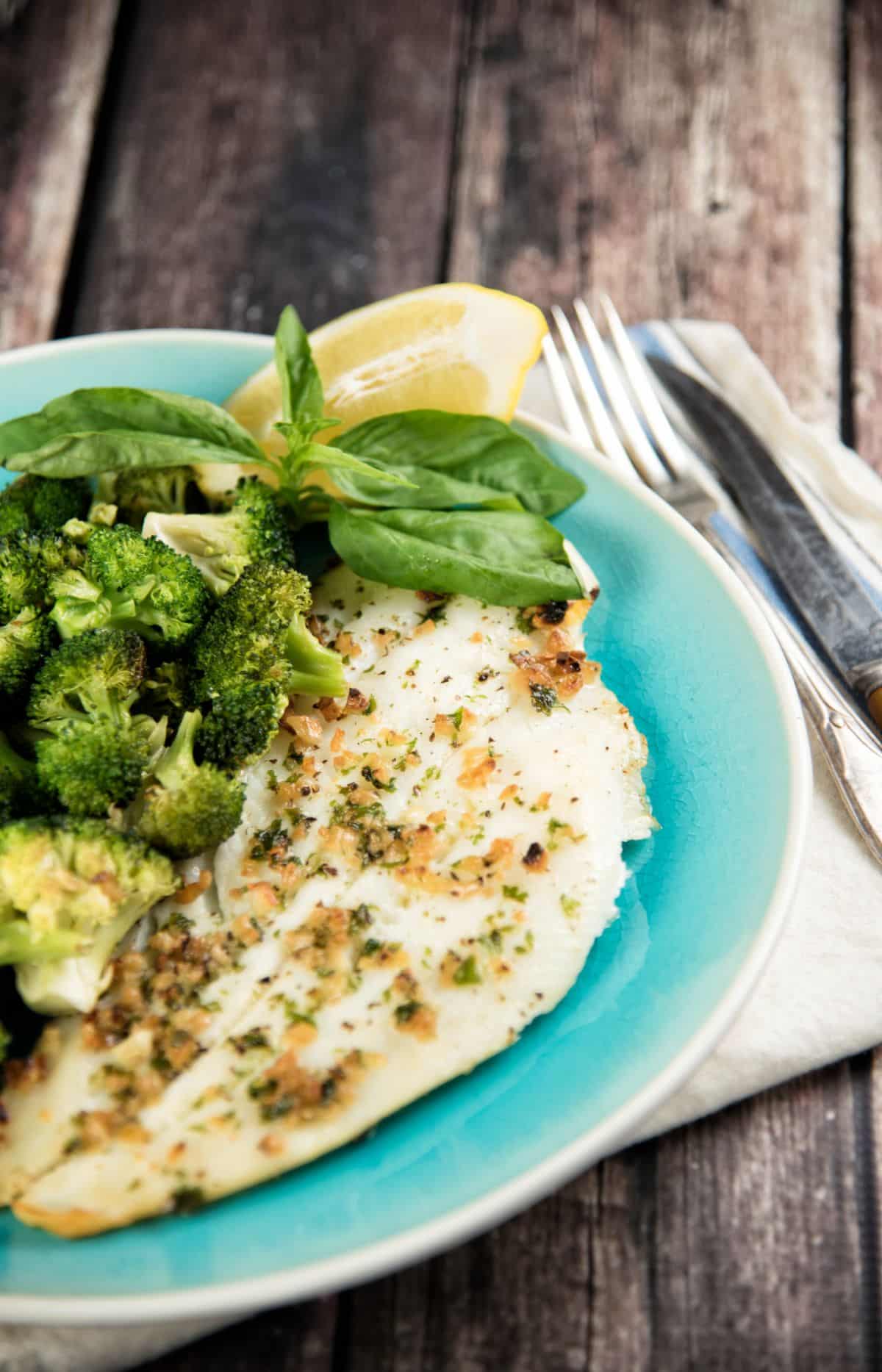 Broiled Halibut with Broccoli and Toasted Garlic on a blue plate.