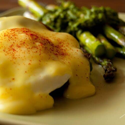 Eggs Benedict with Parsley Asparagus on a plate.