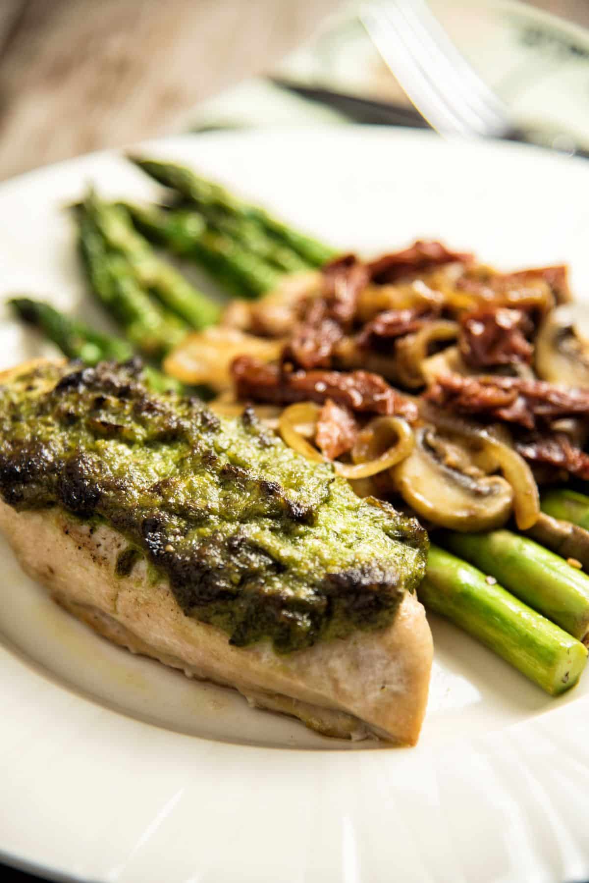 Herb Roasted Chicken Breasts With Pan-Fried Vegetables on a white plate.