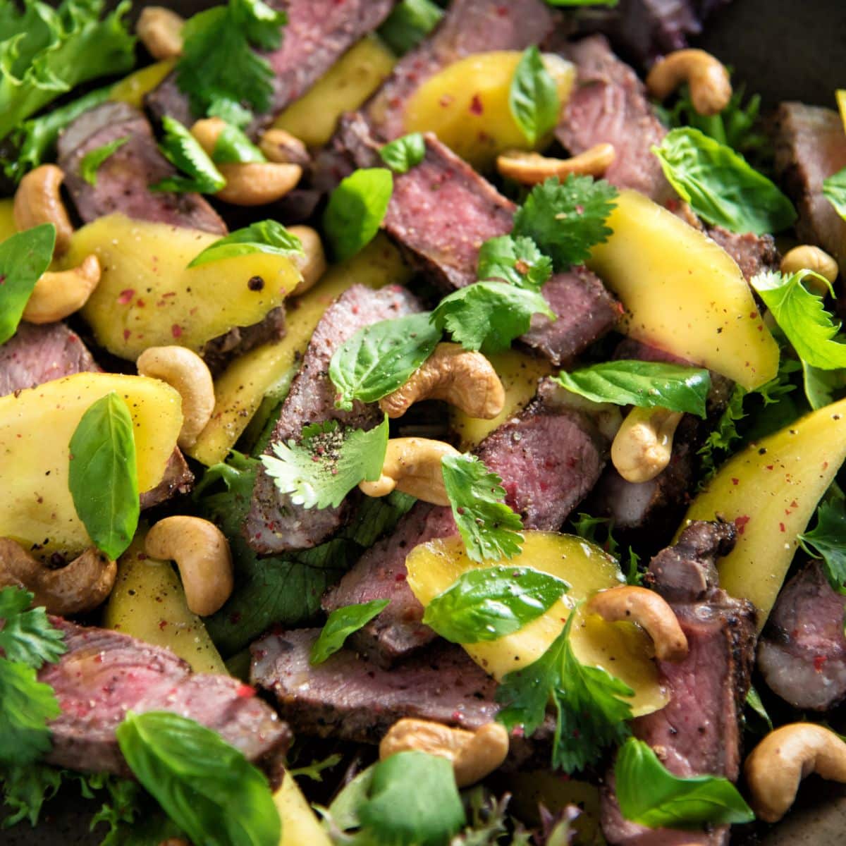 Sirloin Steak and Mango Salad in a black pan.