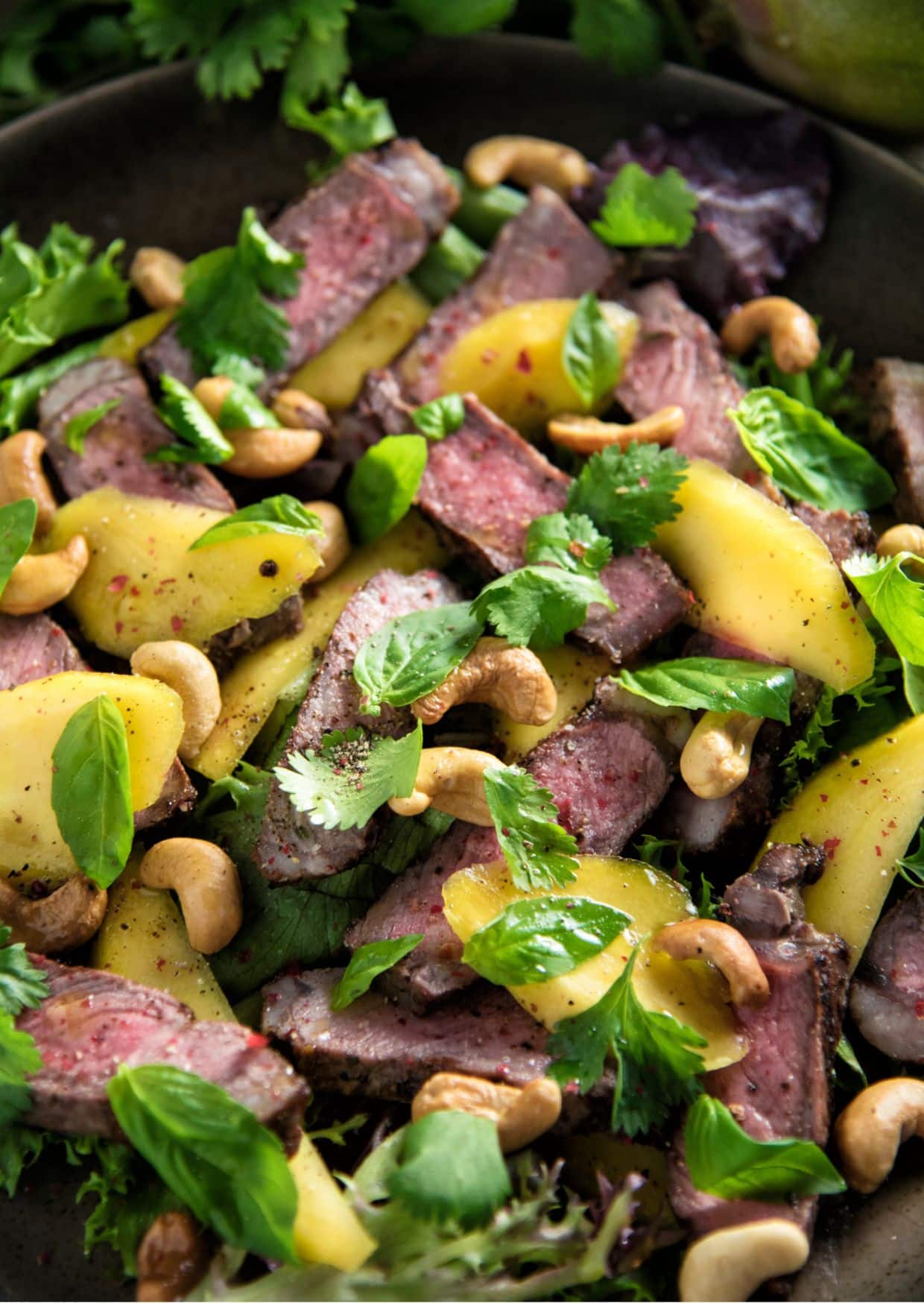 Sirloin Steak and Mango Salad in a black pan.