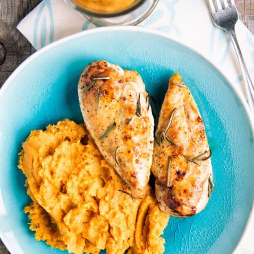 Baked Mustard Chicken With Mashed Sweet Potatoes on a blue plate.