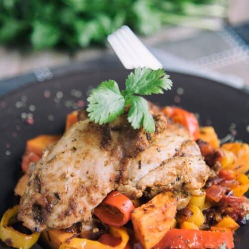 Brazilian Roasted Chicken And Vegetables on a black plate.