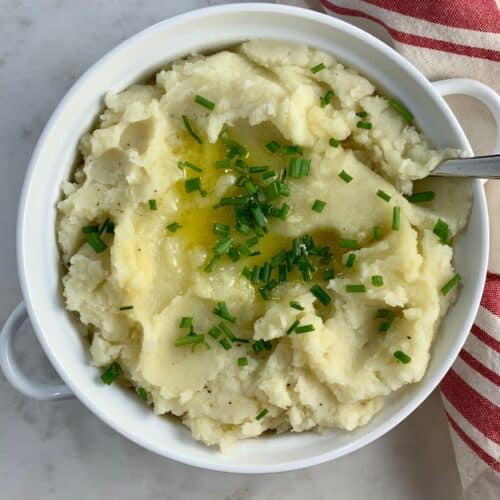 Paleo Mashed Potatoes in a white bowl with a spoon.