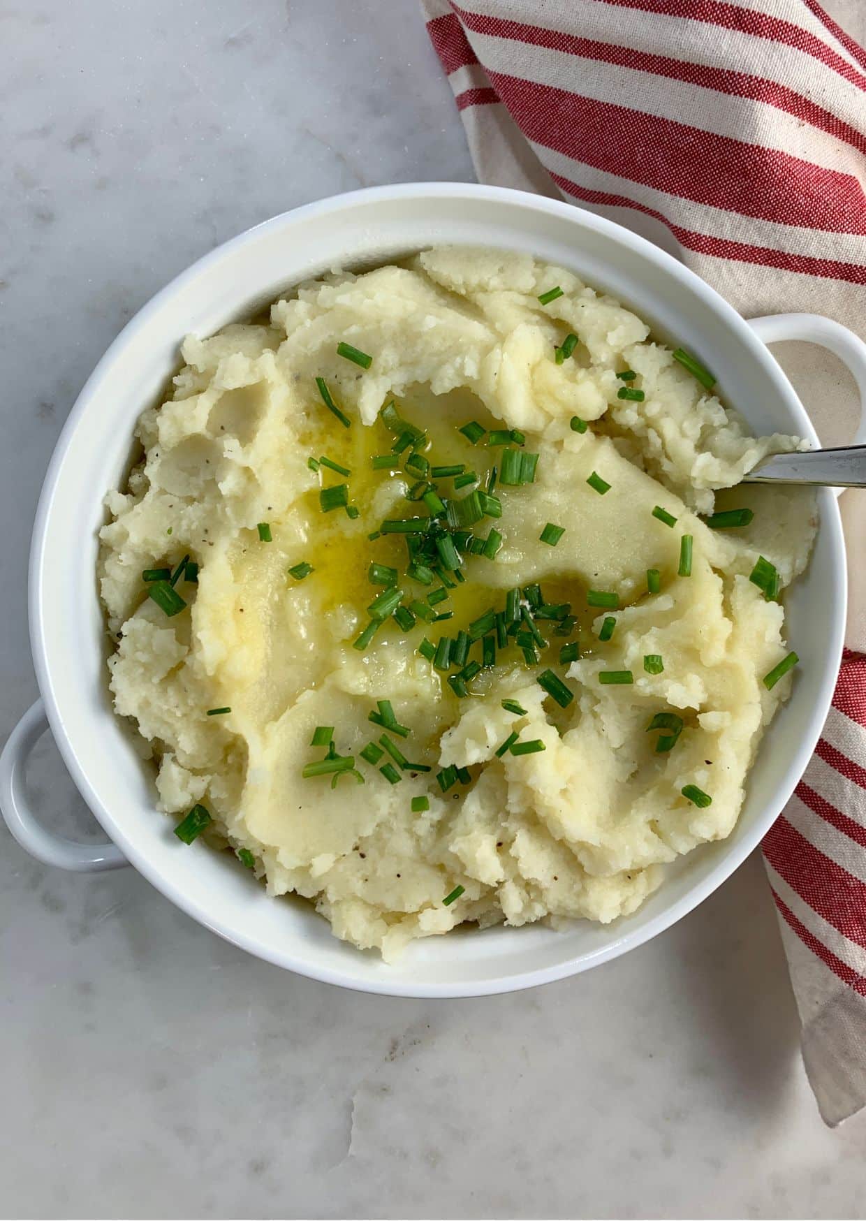 Paleo Mashed Potatoes in a white bowl with a spoon.