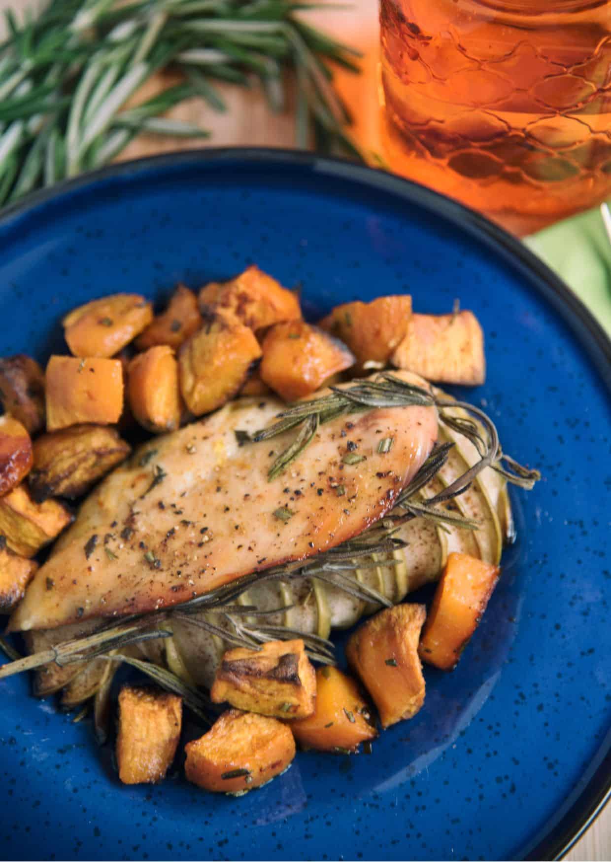 Apple-Stuffed Chicken With Sweet Potatoes on a blue plate.