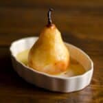 a single baked pear in a white dish