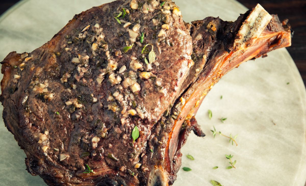slice o beef rib roast with visible herbs and horseradish on outside of steak
