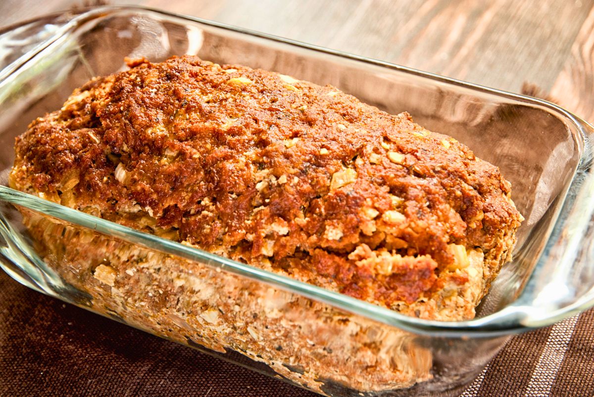 glass loaf pan of meatloaf on wood table