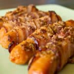 green plate of bacon wrapped sausages