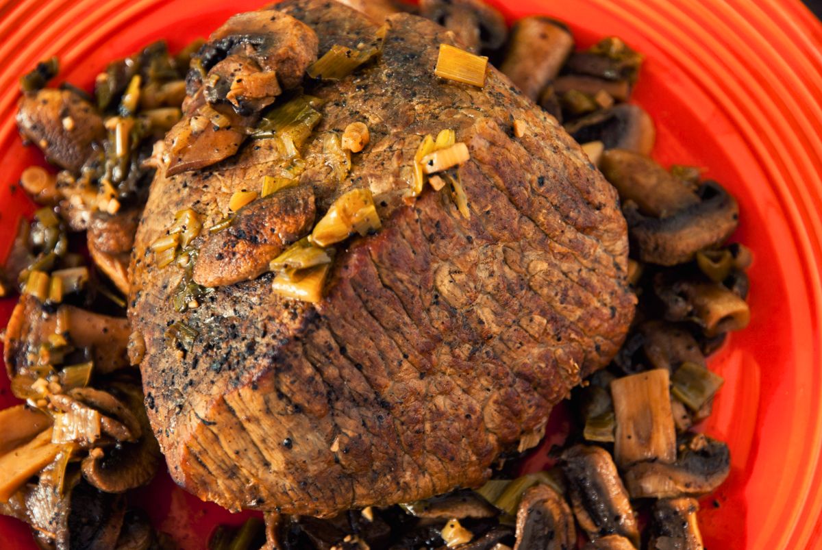 bison and coffee roast on red plate with mushrooms