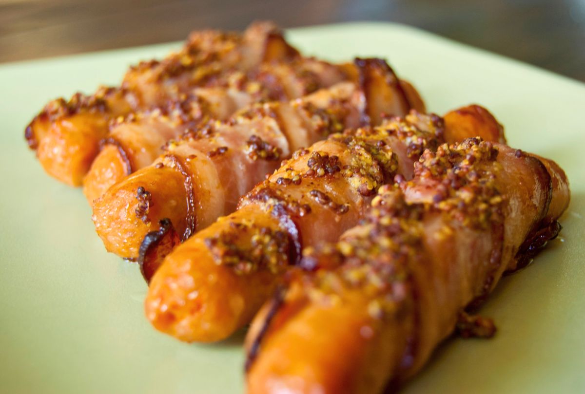 green plate of bacon wrapped sausages