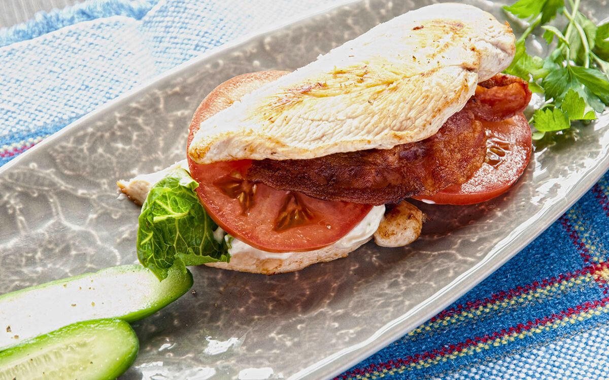 chicken crust paleo blt sandwich with lettuce and tomato on gray platter