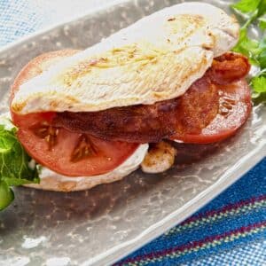 chicken crust paleo blt sandwich with lettuce and tomato on gray platter