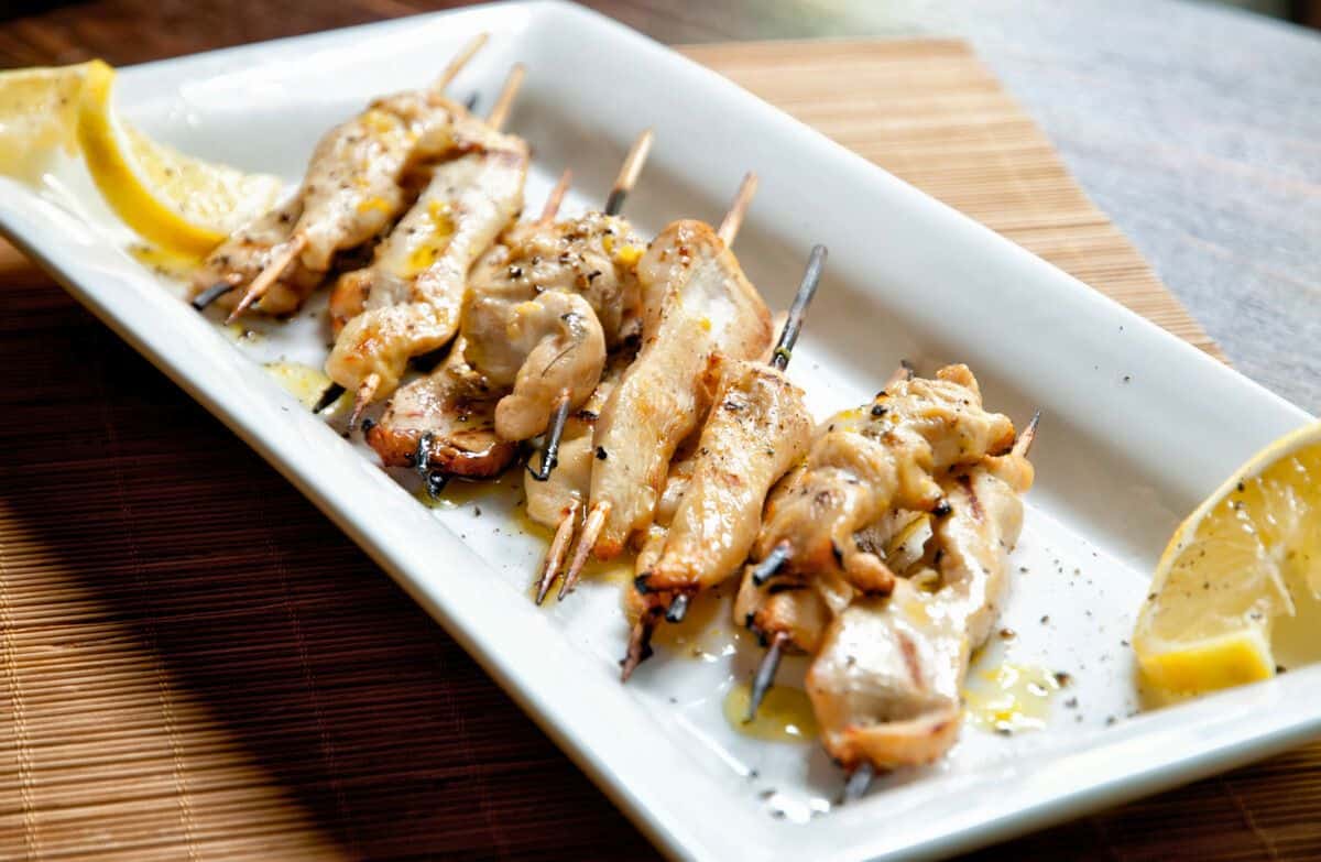 white platter of lemon pepper chicken on skewers