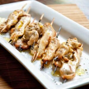 white platter of lemon pepper chicken on skewers