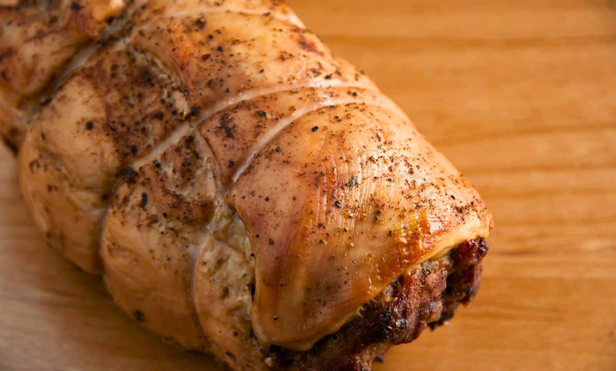 twine wrapped stuffed turkey breast on wooden table