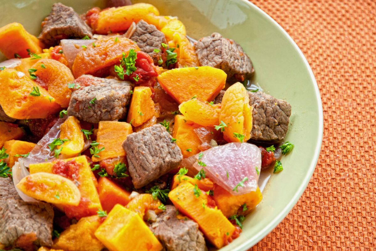 green bowl of paleo beef stew with sweet potatoes