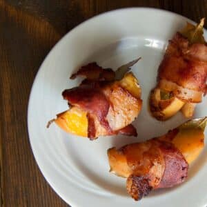 white plate with three Bacon Wrapped Peaches with Basil and Balsamic Vinegar