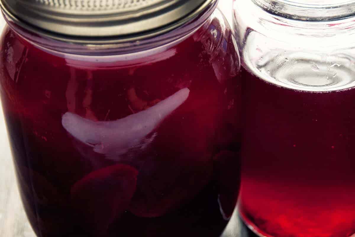 fermented beets closeup in a jar and glass known as Beet Kvass