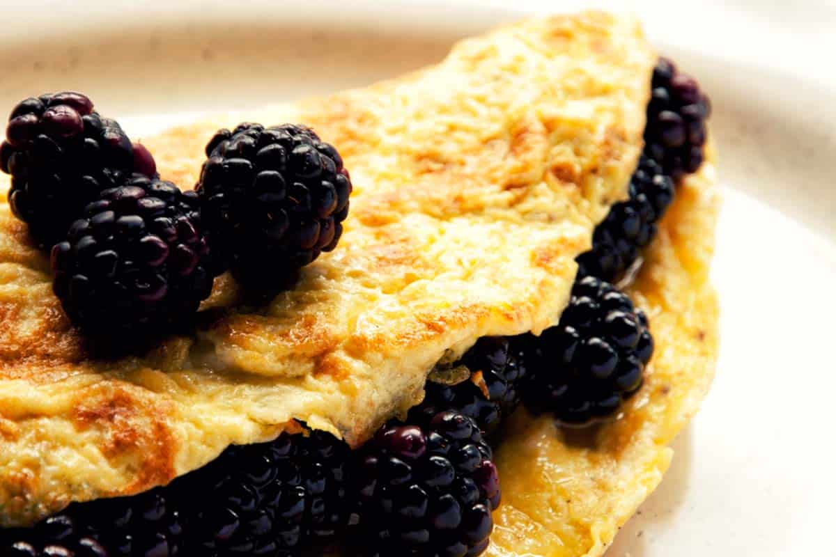 closeup of a Blackberry and honey omelet on a white plate