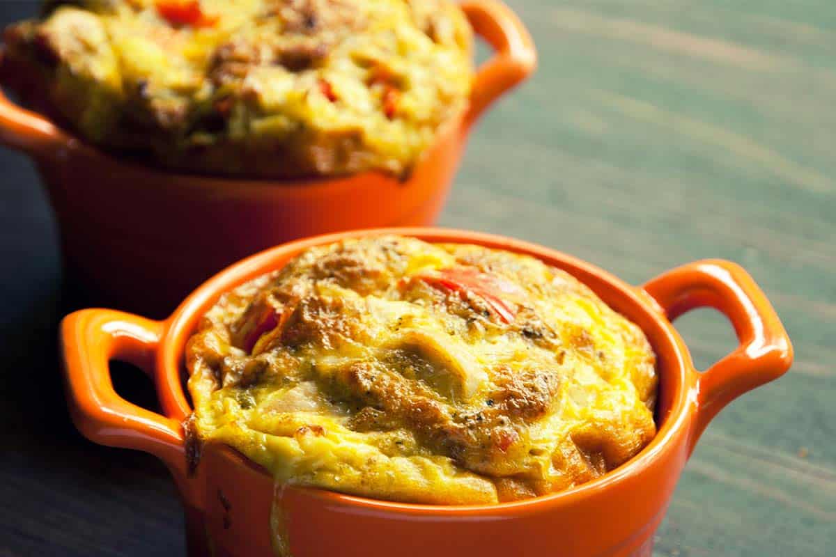 two orange dishes filled with Chicken and egg pie