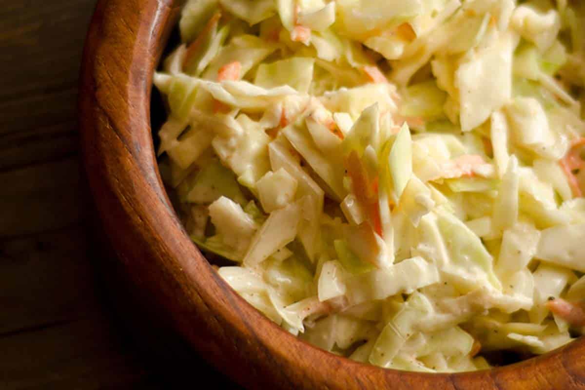 closeup of a brown wood bowl filled with Classic Creamy Coleslaw