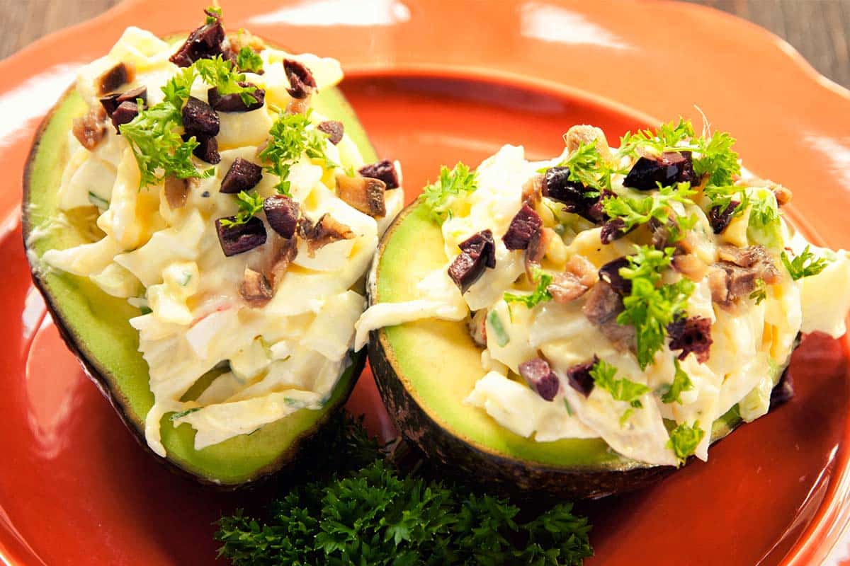 two halves of an avocado stuffed with crab salad to show the results of the Crab-Stuffed Avocados recipe