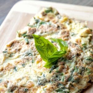 Fresh herb omelet on a wood cutting board