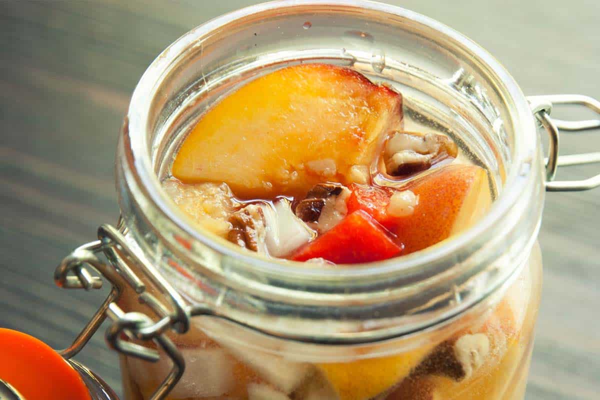 closeup of an open jar of pickled peaches to represent Lacto-Fermented Peach Chutney