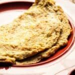 Mustard and chilli omelet served on a red plate