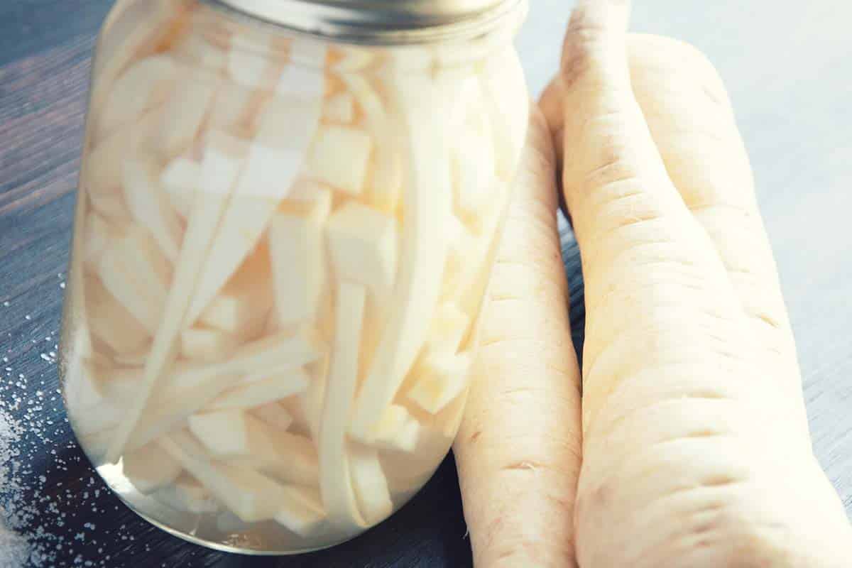 jar of canned turnips next to raw turnips to represent Sauerrüben - lacto-fermented turnips