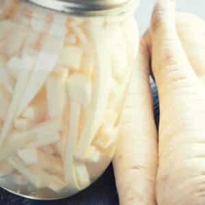 jar of pickled turnips and raw turnips on a table to represent Sauerrüben - lacto-fermented turnips